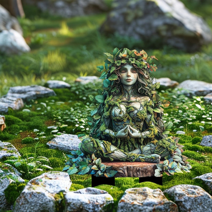 Meditáló, levelekbe öltözött istennő alak fatönkön ülve, mohás kertben, kövek között.