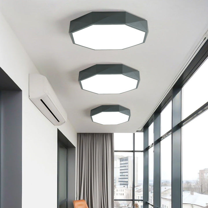 Három szürke sokszögű mennyezeti lámpa különböző méretben egy ablakos folyosó plafonján 2