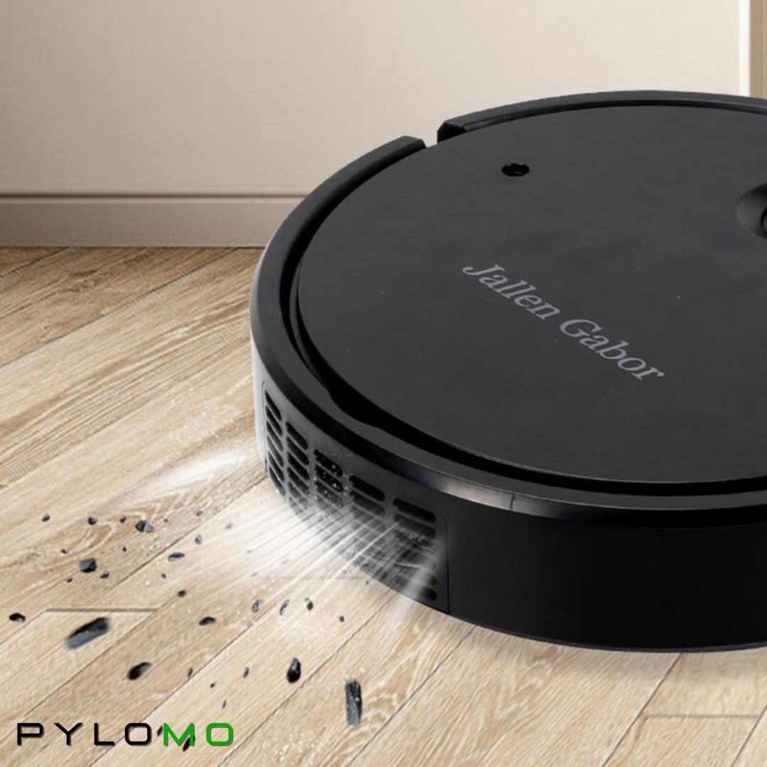 Fekete robotporszívó közeli képe fa padlón, ahogy a szemcséket és morzsákat szívja fel az oldalsó szellőzőnyílás mellett. 5