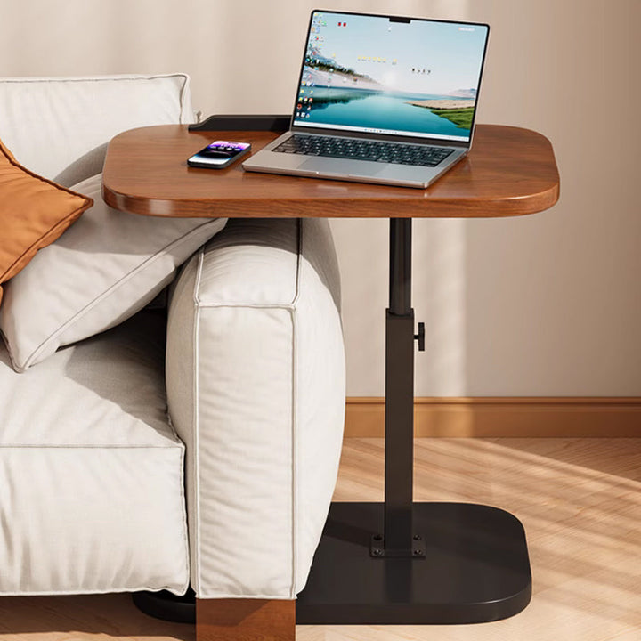 Fekete gurulós laptopasztal, amely a kanapé karfája fölé nyúlik
