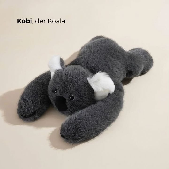 Sötétszürke koala plüss fekvő pózban, fehér fülekkel, nagy fekete orral és hosszú, kinyújtott karokkal. 2