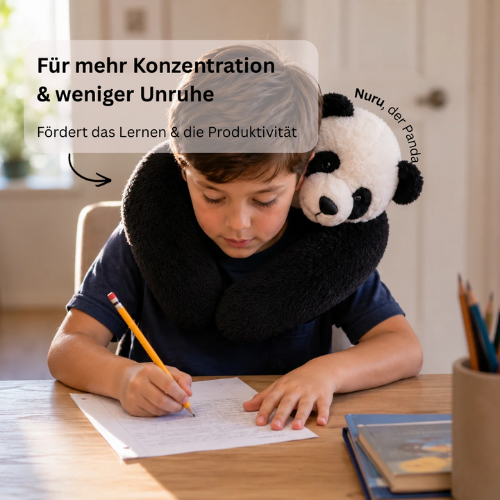Íróasztalnál ceruzával író fiú, nyaka körül fekete-fehér panda plüss, mint puha nyakölelés. 9