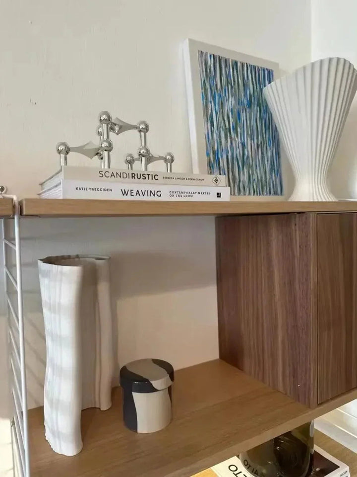 Ezüstös gyertyatartó modulok egy könyvkupacon, részlet.