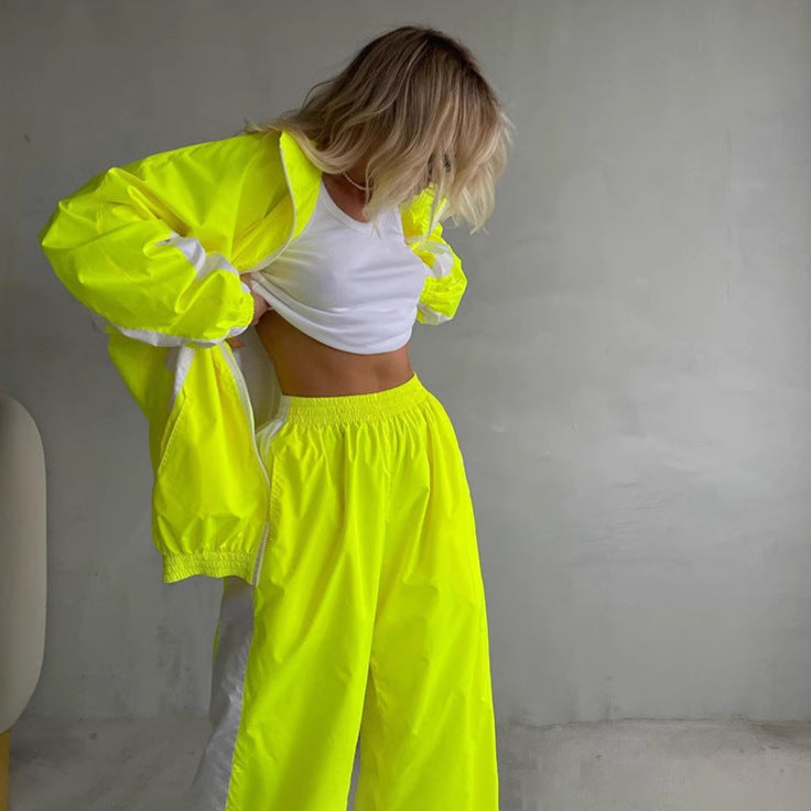 Neonsárga női szett, álló modell, nyitott dzseki és alatta fehér crop top.