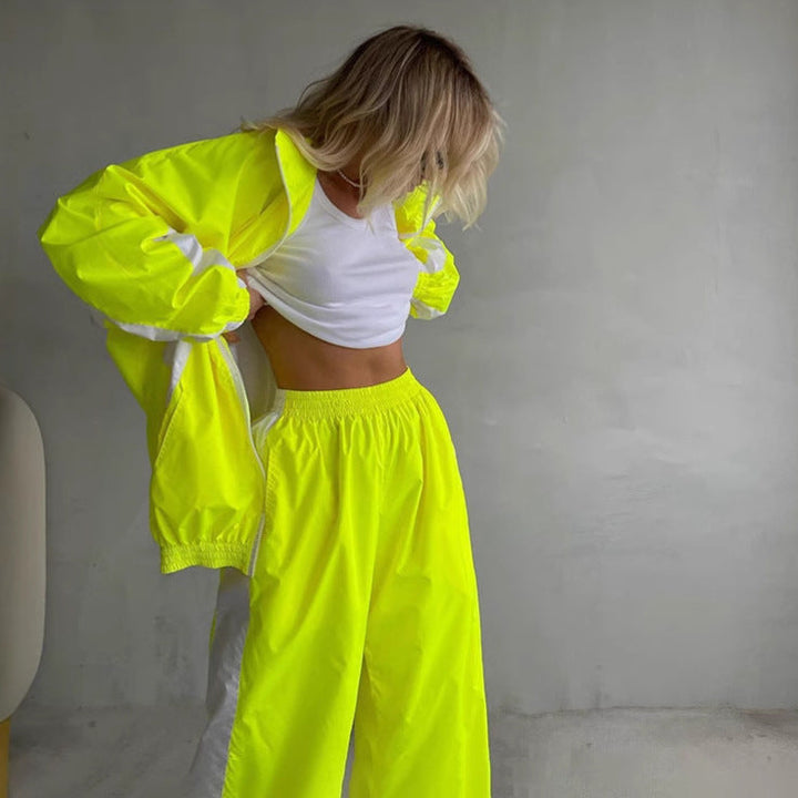 Neonsárga női szett, álló modell, nyitott dzseki és alatta fehér crop top.