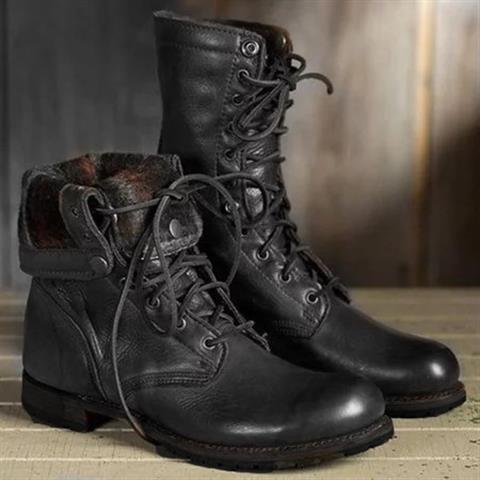 Fekete bőr fűzős bakancspár oldalnézetben, az egyik szára lehajtva, részlet.