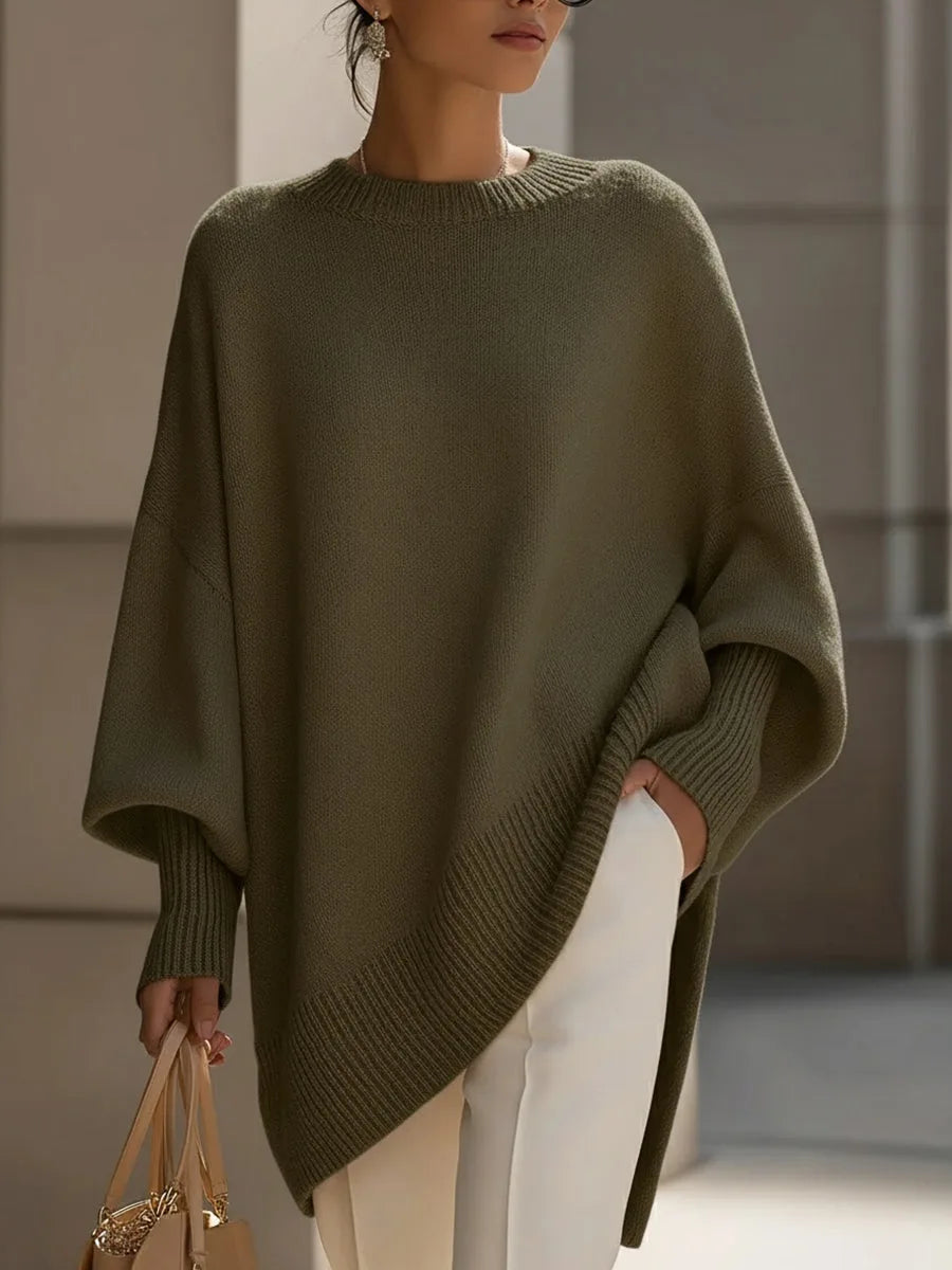 Olajzöld színű oversize pulóver modellen, elölről, ferde bordás aljjal, fehér nadrággal. 7