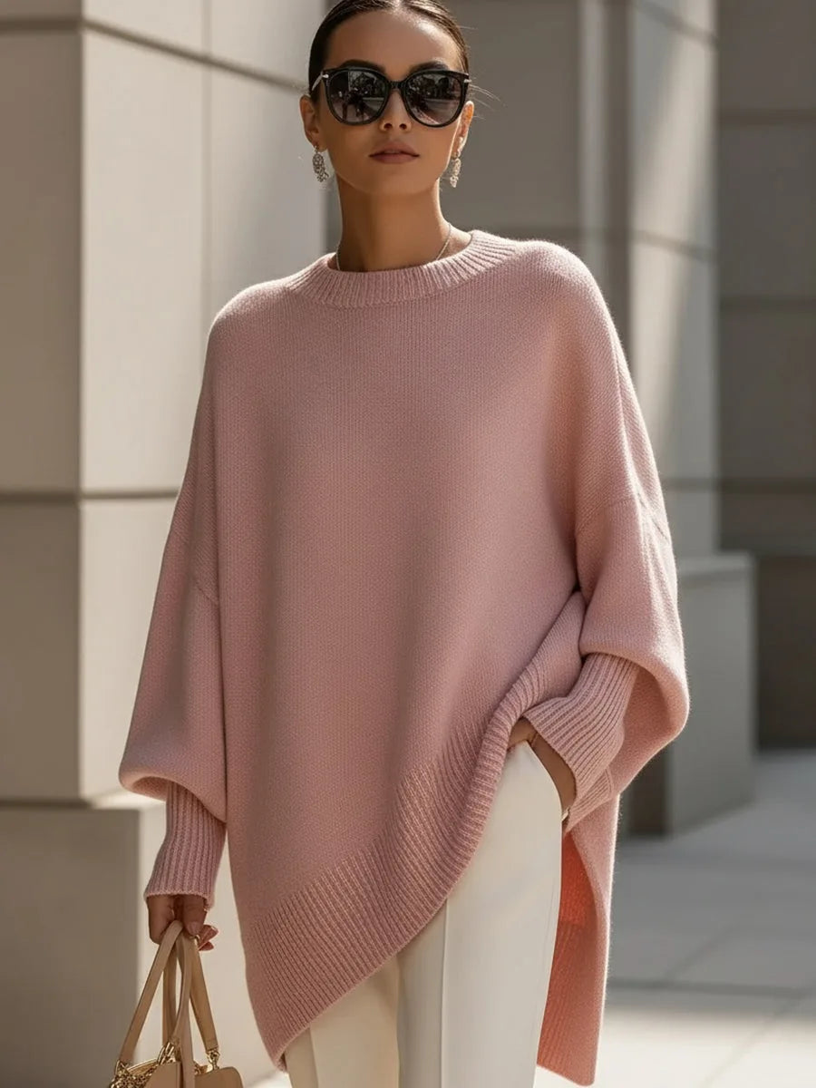 Rózsaszín oversize kötött pulóver modellen, napszemüveggel, fehér nadrággal és bézs kézitáskával. 11