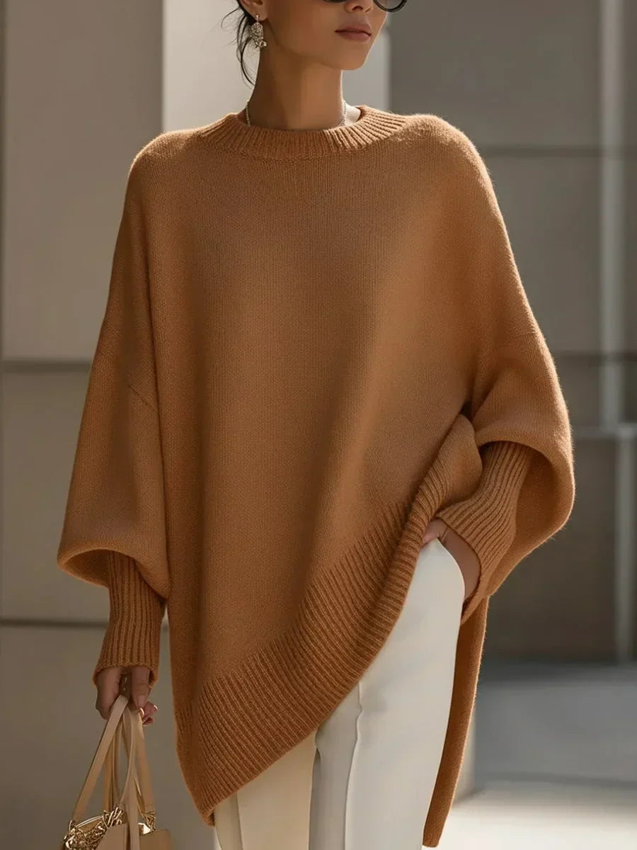 Karamellbarna oversize pulóver modellen, elölről, ferde bordás aljjal, fehér nadrággal és kézitáskával. 12