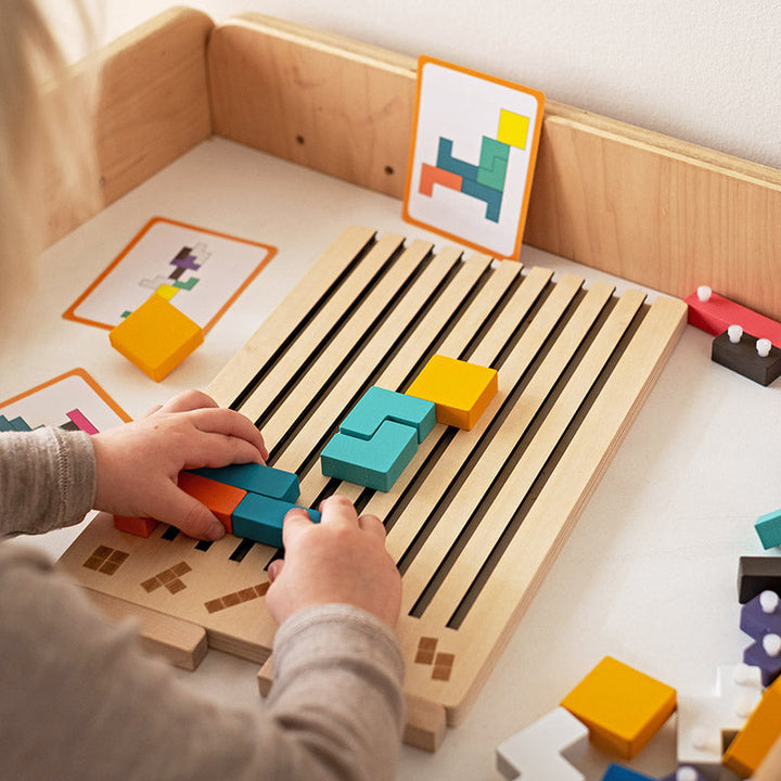 Fa Tetris puzzle játék, gyermek kezei színes elemeket helyeznek a táblára.