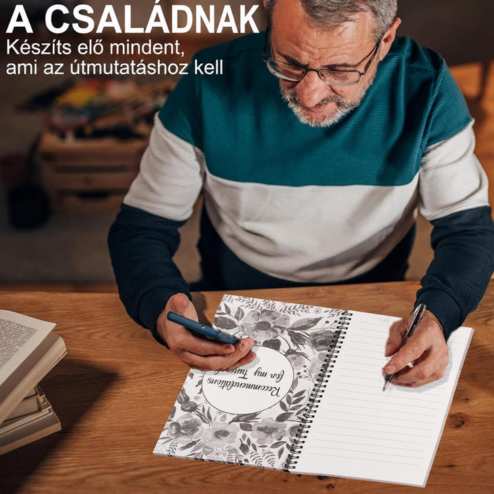 Szemüveges idős férfi asztalnál telefont tart és tollal ír a kinyitott, spirálkötésű tervezőbe, virágmintás elválasztólap és vonalas oldal látszik. 4