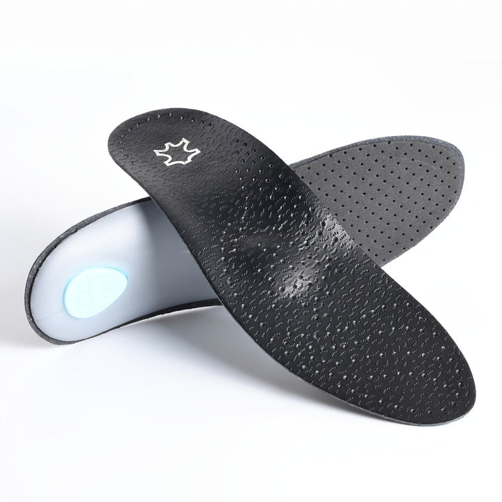 Két fekete talpbetét egymásra támasztva világos háttér előtt: az egyiken a mintázott felső felület, a másikon a kék sarokpárna látszik.
