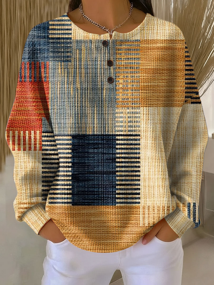 Háromgombos, gofriszerű kötésű pulóver modellen, kék, narancs és piros csíkos, patchwork hatású mintával. 3