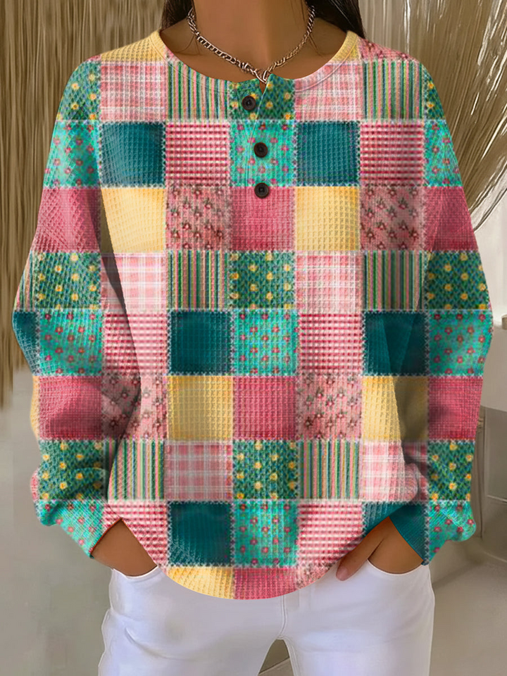 Gofriszemű pulóver modellen, rózsaszín, zöld és sárga patchwork-négyzetes mintával, háromgombos nyakkal. 20