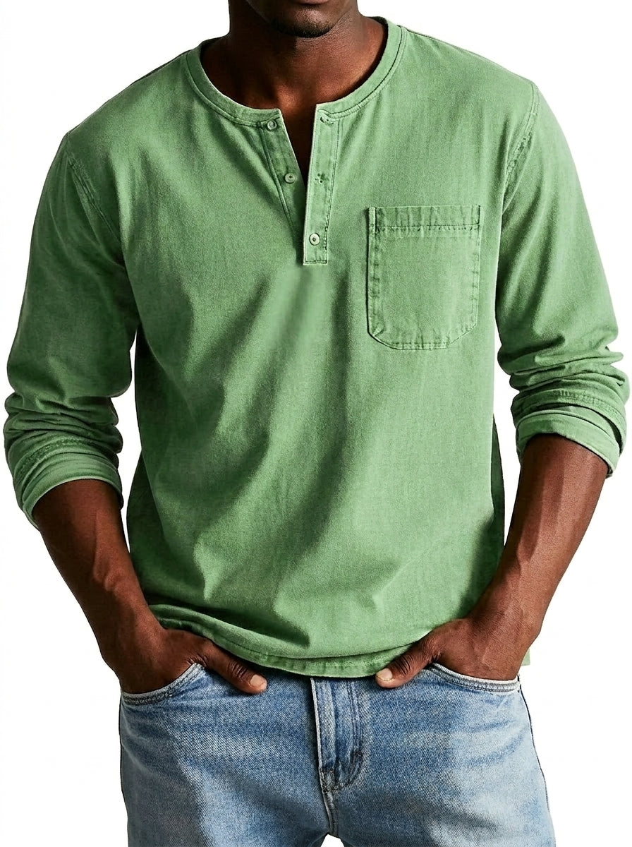 Világoszöld férfi Henley felső elölről, modellen, farmerrel viselve; látszik a gombsor a kerek nyakkivágásnál és a mellzseb.