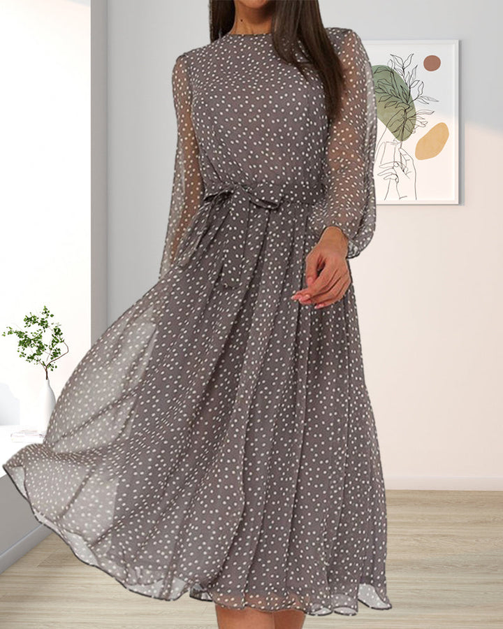 A hosszú ujjú, pöttyös midi ruha modellen, másik nézet, világos szobában.