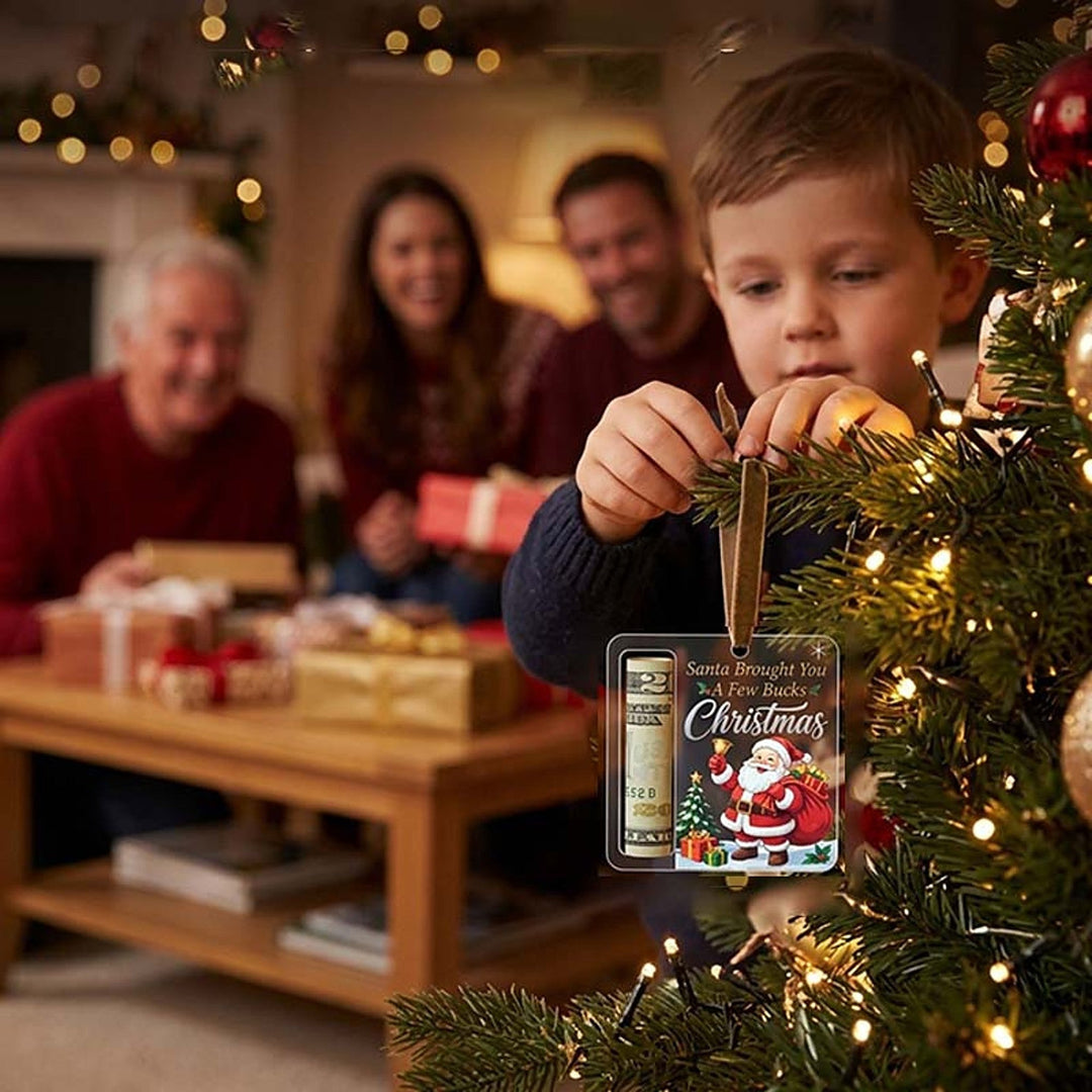 Fiú akasztja a fa ágára az akril díszt, benne feltekert bankjeggyel.