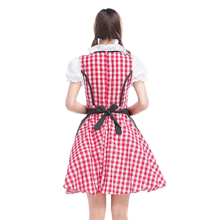 Piros-fehér kockás női dirndl hátulnézetben sötétzöld masnis köténnyel és fehér puffos ujjú blúzzal.