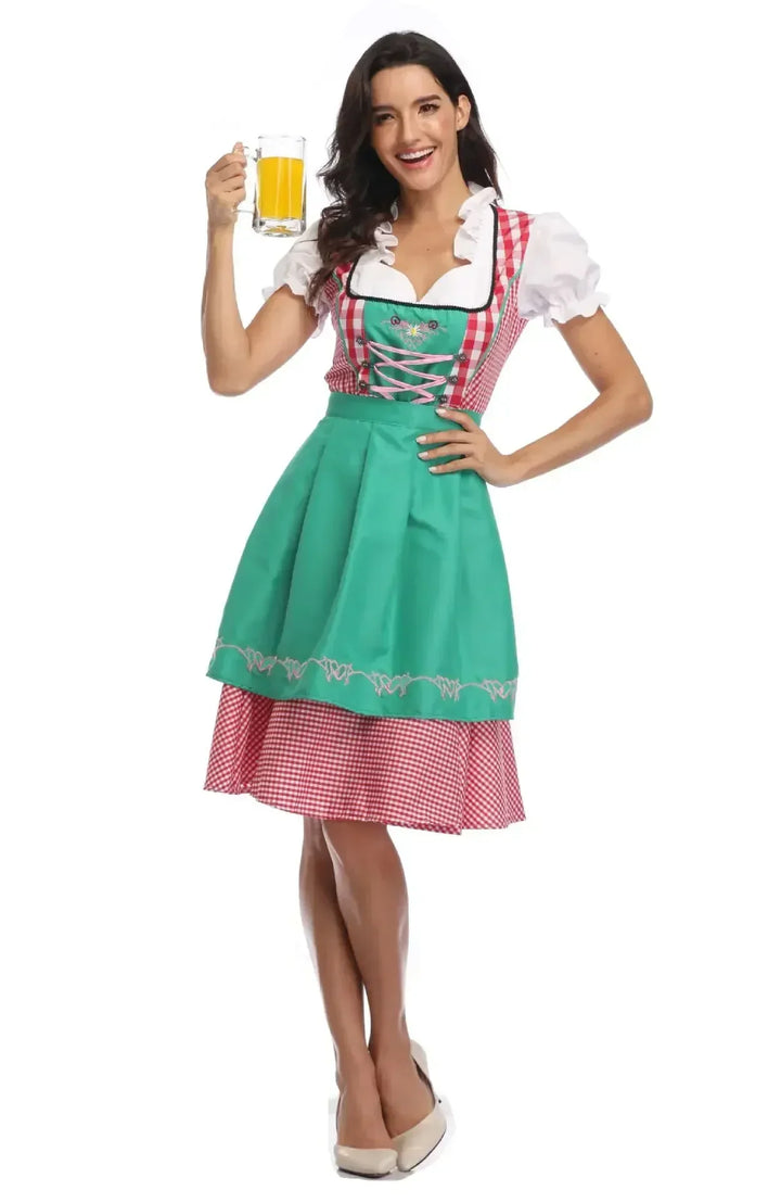 Piros kockás női dirndl zöld hímzett köténnyel és fehér fodros blúzzal.