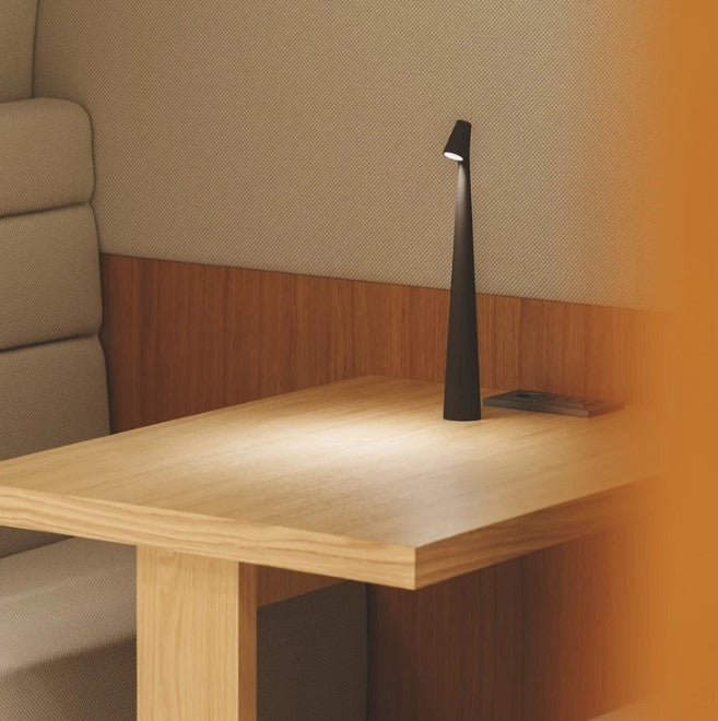 Fekete LED asztali lámpa egy tölgyfa asztalon, detail.