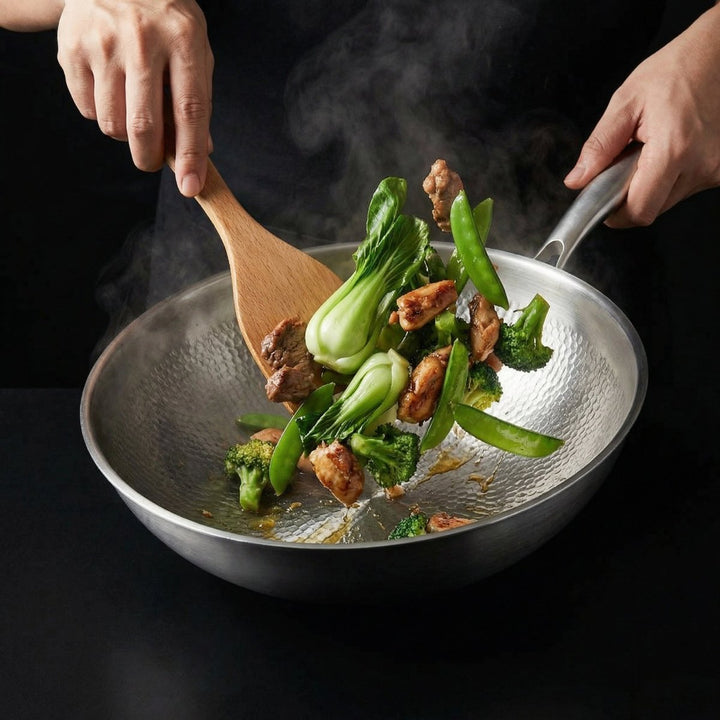 Kalapált titán lapos aljú wok serpenyőben pak choi, brokkoli, cukorborsó és húsdarabok keverése.
