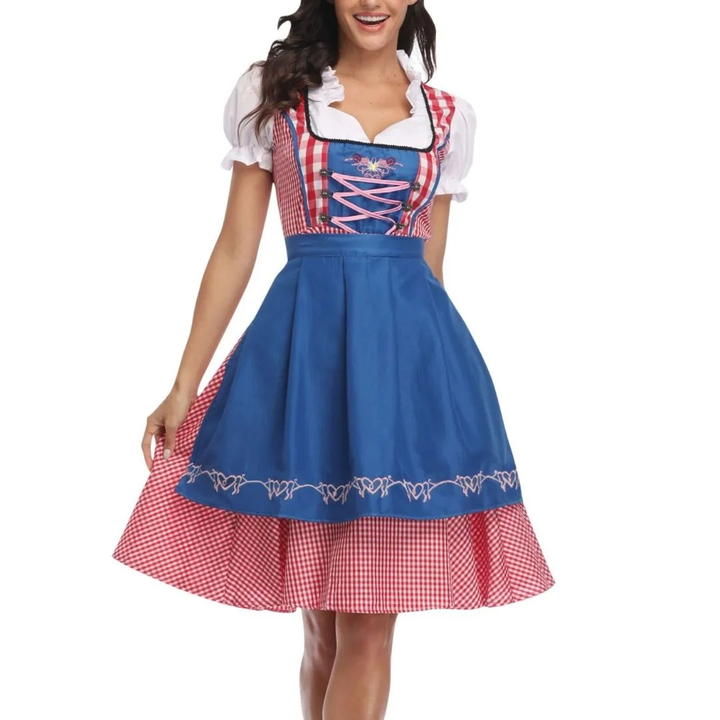 Piros kockás dirndl élénkkék köténnyel, fűzős felsőrésszel és hímzett szegéllyel, elölnézetben.
